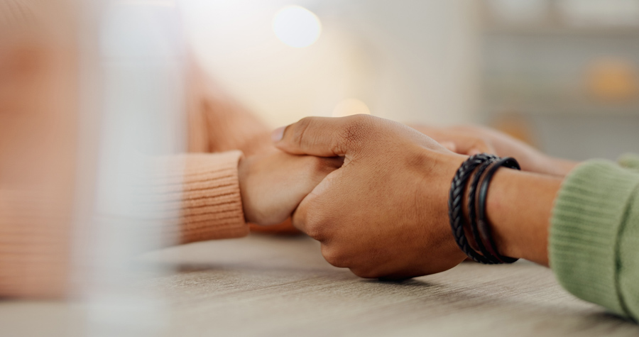 Contact and connection two people holding hands across table